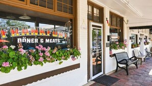 A storefront with a sign reading 'FRANKFURT DÖNER & MEATS' and a list of opening hours.
