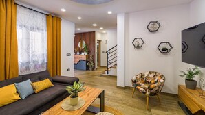 A modern living room with a sofa, coffee table, and decorative wall art. - Stunning home in Sajini (Sajini)