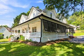 A two-story house with a covered porch and a fenced yard. - The Ball Ground House (Ball Ground)
