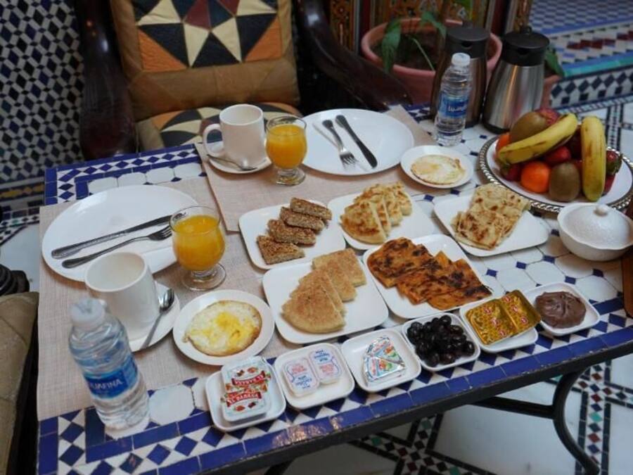 A breakfast table with various dishes, including toast, eggs, and fruit.