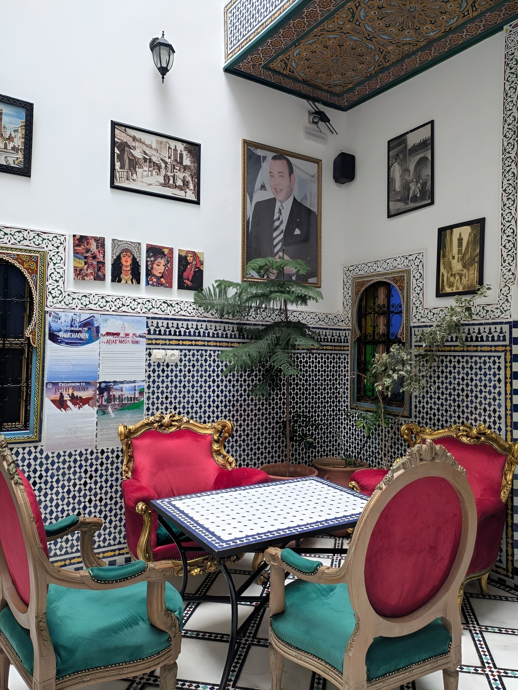 Ein Zimmer mit Wandverkleidung, einem großen gerahmten Gemälde und einem Tisch mit Stühlen.