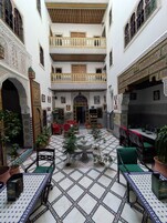 Um pátio com arquitetura elaborada, uma fonte e áreas de estar.