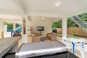 Een moderne woonkamer met een bank, een televisie en een barbecuehoek.