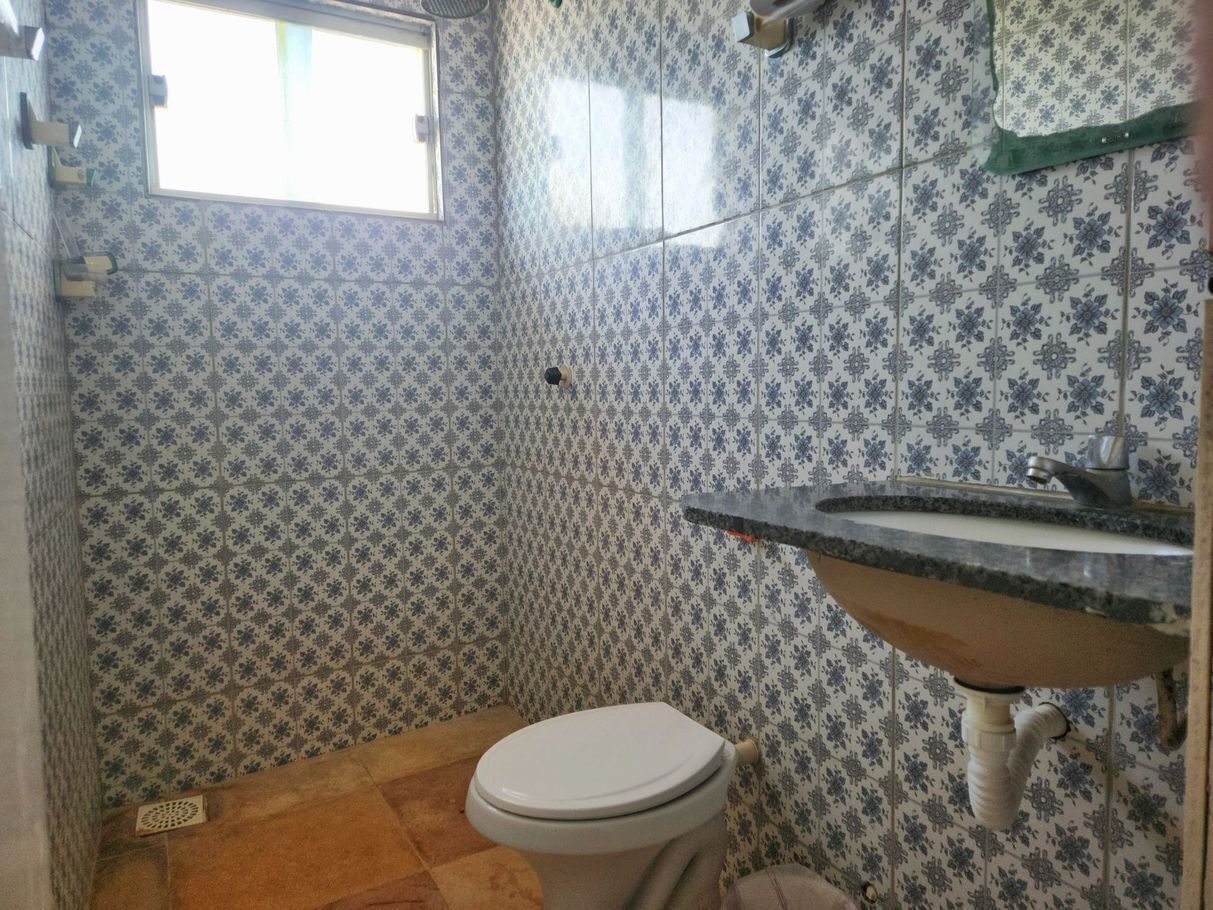 A small bathroom with a toilet, sink, and patterned tiles.