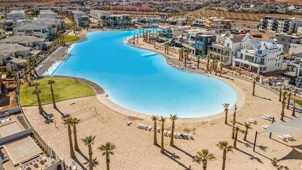 Un complexe hôtelier doté d’une grande piscine, d’une plage et de bâtiments modernes.