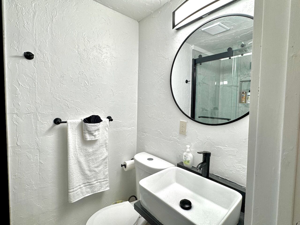 Ein kleines Badezimmer mit Toilette, Waschbecken und Spiegel.