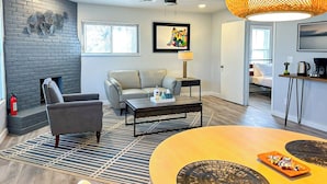 Una sala de estar moderna con chimenea, un sofá, una mesa de centro y un comedor con mesa y sillas.