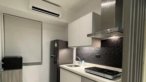 Une cuisine moderne équipée d’une cuisinière intégrée, d’un réfrigérateur et d’un four à micro-ondes.