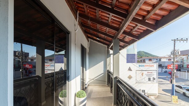 A balcony with a view of a street, a sign for 'DOIS IRMÃOS' with a contact number, and a 'RINNAI' advertisement. - Apt With Barbecue 200 m From the Beach Ifa0054 (Penha)