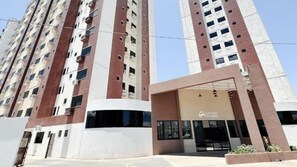 A high-rise building with multiple balconies and a ground-level entrance with a sign reading "Golden Dolphin". - Caldas Novas - Golden Dolphin Supreme (Caldas Novas)
