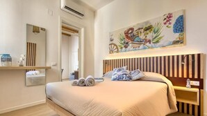 A bedroom with a large bed, a wooden headboard, a painting above the bed, and a mirror on the wall. - VFH La Rada Apartments (Porticello)