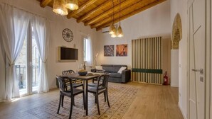 A cozy living room with a dining table, chairs, a sofa, and a fireplace. - VFH La Rada Apartments (Porticello)
