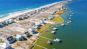 A coastal property with beachfront houses and piers extending into the water. - Waterfront Views - Walk to Beach - Heated Pool (Gulf Shores)