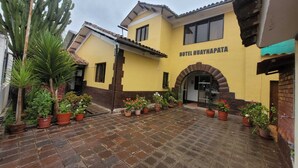 A yellow building with a sign reading "HOTEL HUAYNAPATA". - HOTEL HUAYNAPATA PARDO (Cusco)