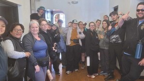 A group of people in a hallway with a patterned floor, a door, and a light fixture on the ceiling. - HOTEL HUAYNAPATA PARDO (Cusco)