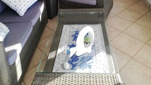 Ein gemütliches Wohnzimmer mit Korbmöbeln, einem Esstisch und einem Bett mit Baldachin.