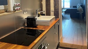 A modern kitchen with a wooden countertop, stainless steel appliances, and a large window.