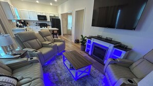 A modern living room with a beige sectional sofa, a wooden coffee table, and a fireplace.