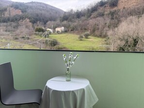 A balcony with a table, a chair, and a vase with flowers. - HOTEL PICCOLO PARADISO  (Latronico)