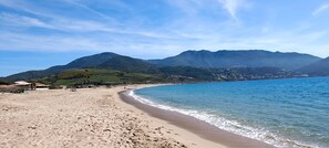 Ein Strand mit freiem Blick auf Berge im Hintergrund.