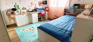 A child's bedroom with a desk, chair, and a bed with a blue bedspread. - House 90m2. In the calm of Alata. 15 minutes from Ajaccio and the beaches (ALATA)