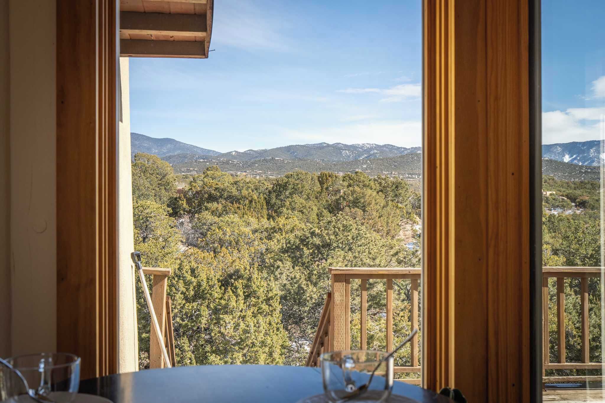 Une chambre dotée d’un balcon en bois donnant sur un paysage montagneux.