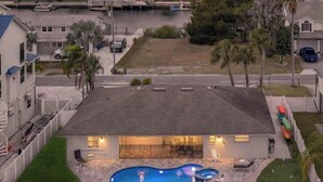 A residential area with a swimming pool, a dock, and a sunset view. - NEW! Waterfront Gulf Retreat w/ Heated Pool, Spa, & Mini Golf. (Hernando Beach)