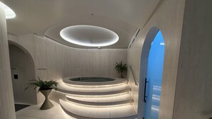 A modern interior with a central circular seating area, a staircase leading to an upper level, and a large potted plant. - Adagio apartments by Nomad-In (Quito)
