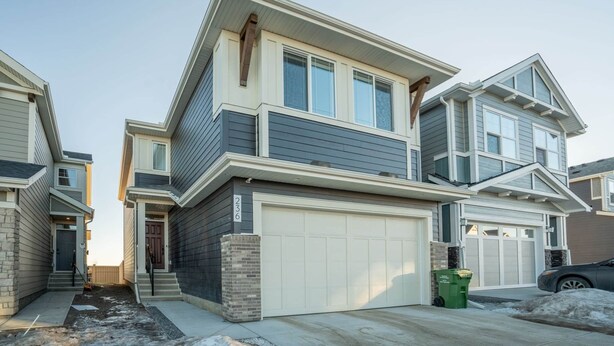 A modern two-story house with a garage, a front porch, and a driveway.