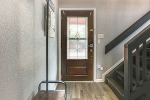 A wooden door with a glass panel, a metal handrail, and a staircase with wooden steps. - Golf, Boat, Swim! Point Venture Retreat w/ Deck (Lago Vista)