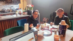Un coin repas avec un ordinateur, une boîte de McDonald's et divers plats disposés sur la table.