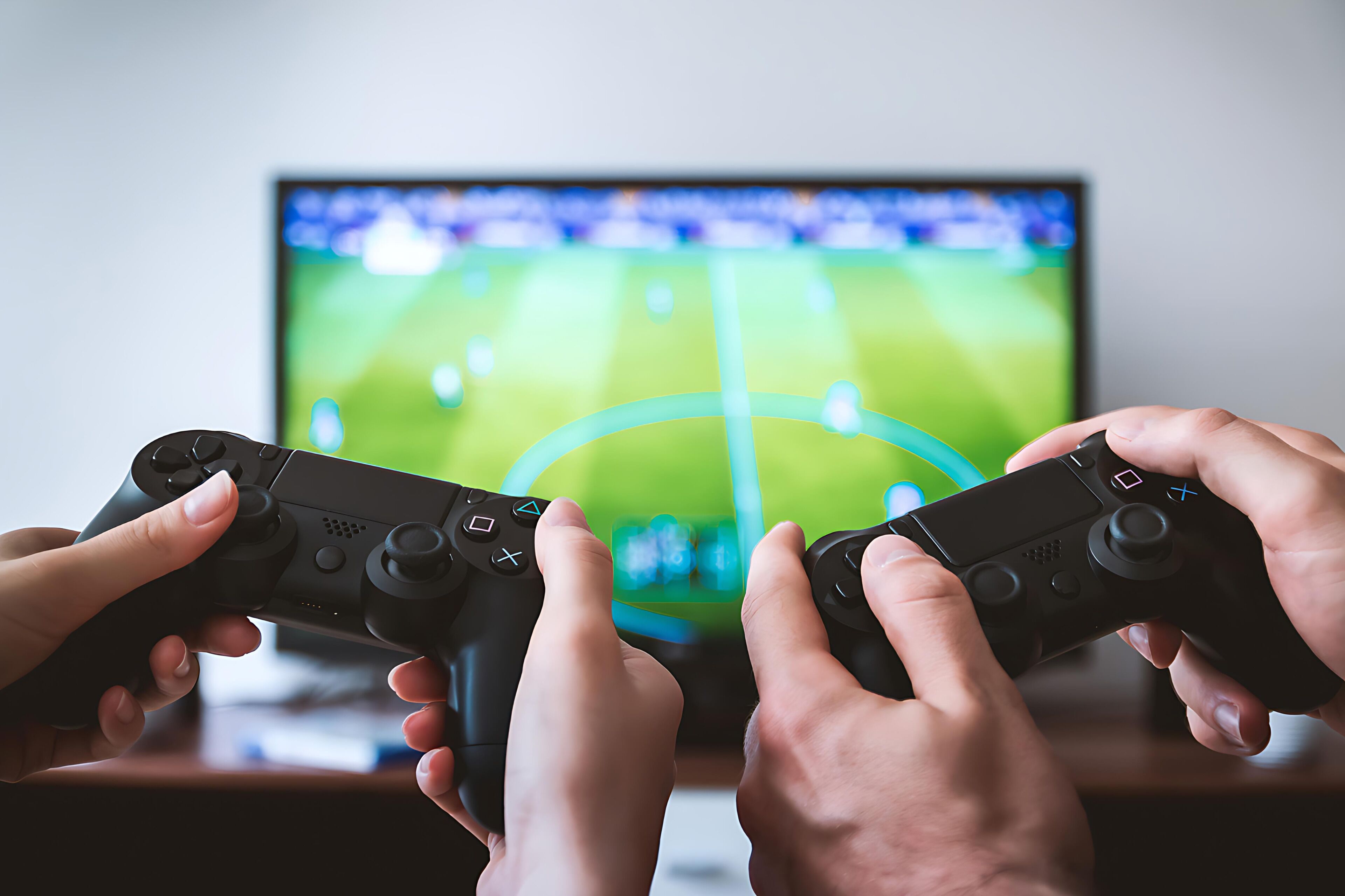 Two people playing a video game with a TV in the background.