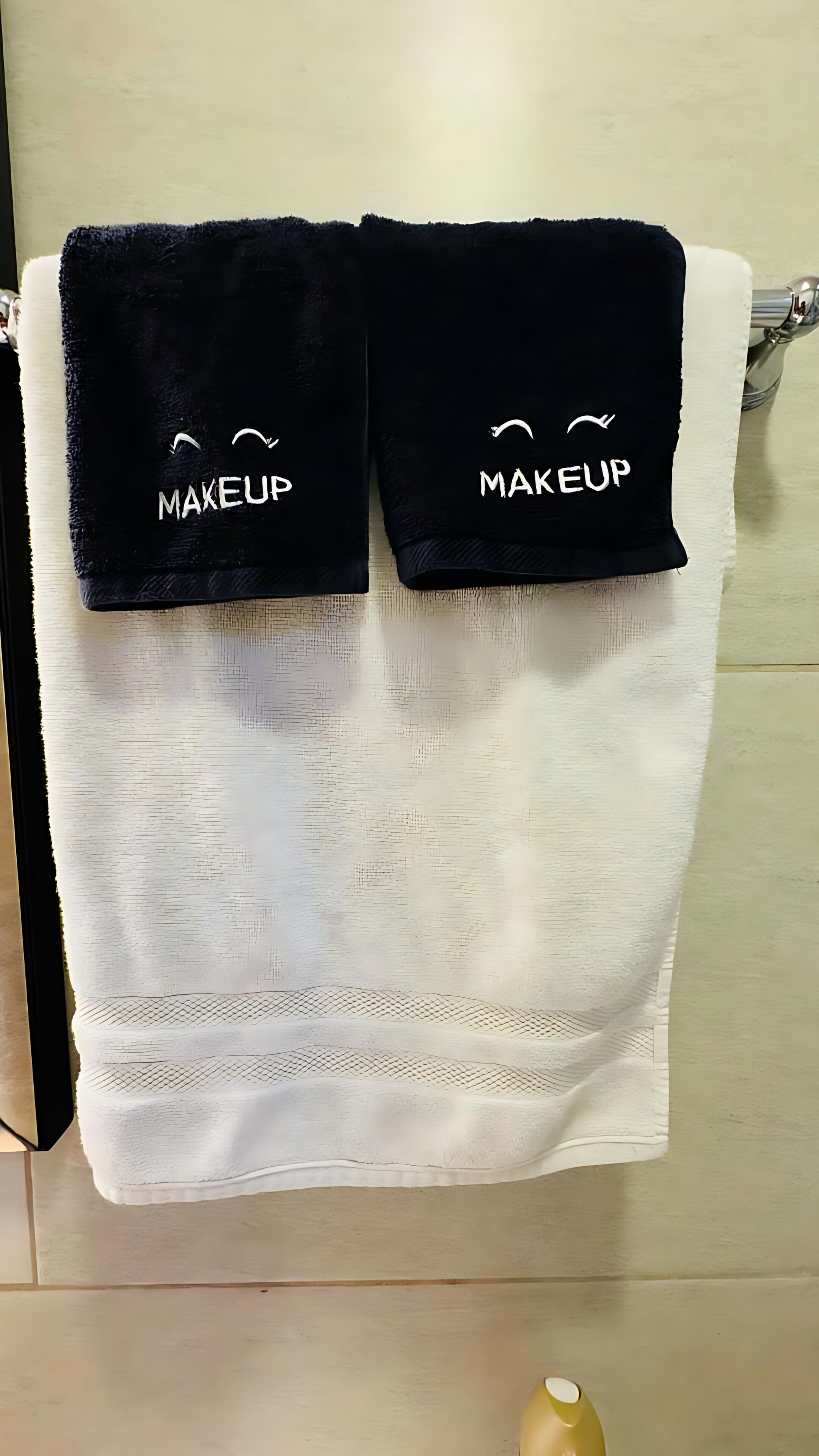 A white towel with two dark blue towels on top, each labeled "MAKEUP".