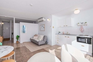 A modern apartment with a living room, kitchen, and dining area. - Boho Oceanview Getaway (Gold Coast)