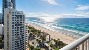 A coastal view with a beach, a tall building, and a clear sky. - Boho Oceanview Getaway (Gold Coast)