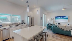 Una cucina moderna con isola centrale, elettrodomestici in acciaio inossidabile e un'area pranzo con sgabelli.