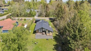 A modern cabin with a deck, surrounded by dense forest and a lake view. - Cozy little cottage, close to the Limfjord (Storvorde)
