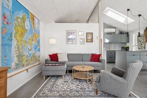 Una sala moderna con un mapa grande, un sofá, una mesa de centro y una silla.