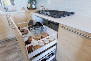 A kitchen with a built-in stove, wooden cabinets, and a white countertop.