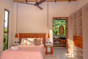 Une chambre à coucher avec un lit, une table de chevet et une vue sur l’extérieur.