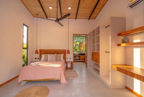 A bedroom with a bed, a ceiling fan, a window, and built-in wooden shelving. - Villa Yakole– Spacious Tropical Retreat (Puerto Viejo)