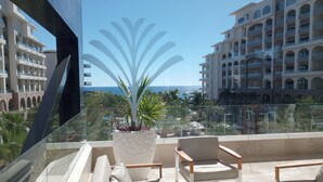 A balcony with a potted plant, two chairs, and a table. - Luxurious Oceanfront 5 STAR Resort Suite at Villa la Valencia with a Lazy River! (San José del Cabo)