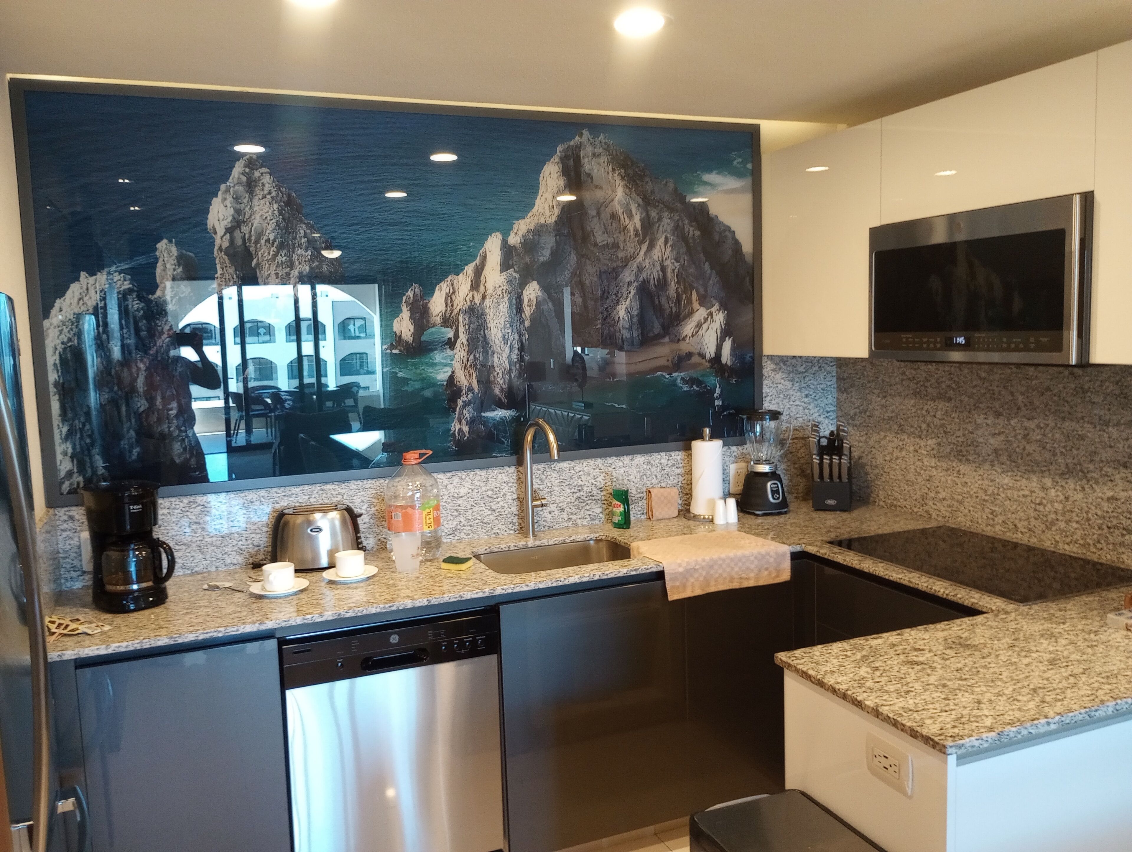 Una cocina moderna con encimeras de granito, electrodomésticos de acero inoxidable y una isla grande.