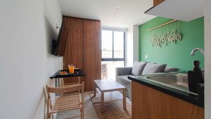 A compact kitchen with a dining area, a sofa, and a view through a window. - Relajante estudio con espacio óptimo y balcón (Guadalajara)