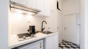 Una cocina compacta con estufa integrada, cafetera y lavavajillas.