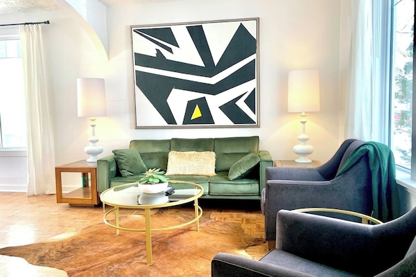 Main-floor living room with original hardwood floors, comfortable seating for 5, and natural light.