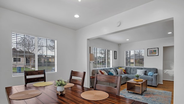 A modern living room with a dining area, featuring a wooden dining table, chairs, and a grey sofa. - Brilliant 5-bedroom single level house in charming Alhambra (Alhambra)