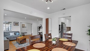 A dining area with a wooden table, four chairs, and a central vase. - Brilliant 5-bedroom single level house in charming Alhambra (Alhambra)