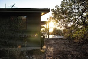 Ein kleines, eingeschossiges Gebäude mit dem Schild "Valley Beach House", geneigtem Dach und einer sichtbaren Antenne.