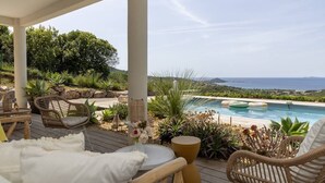 A covered outdoor area with a pool, wicker furniture, and a view of the landscape. - Villa LAETIZIA- 5 bedrooms, swimming pool, sea view (PIETROSELLA)